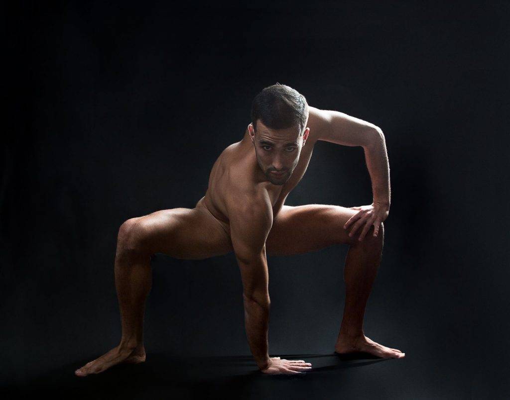 Víctor Óscar Juaranz - Cuerpo desnudo con mano derecha apoyada en el suelo sobre fondo negro - Horizontal - Color