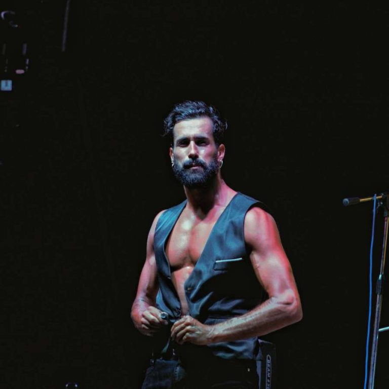 Víctor Óscar Juaranz - Vive un sueño - Plano medio con traje negro sin mangas y fondo oscuro