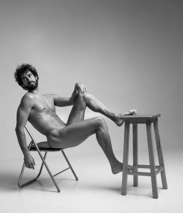 Víctor Óscar Juaranz - Cuerpo entero desnudo sentado en una silla con el pie izquierdo apoyado en un taburete - Vertical - Blanco y negro